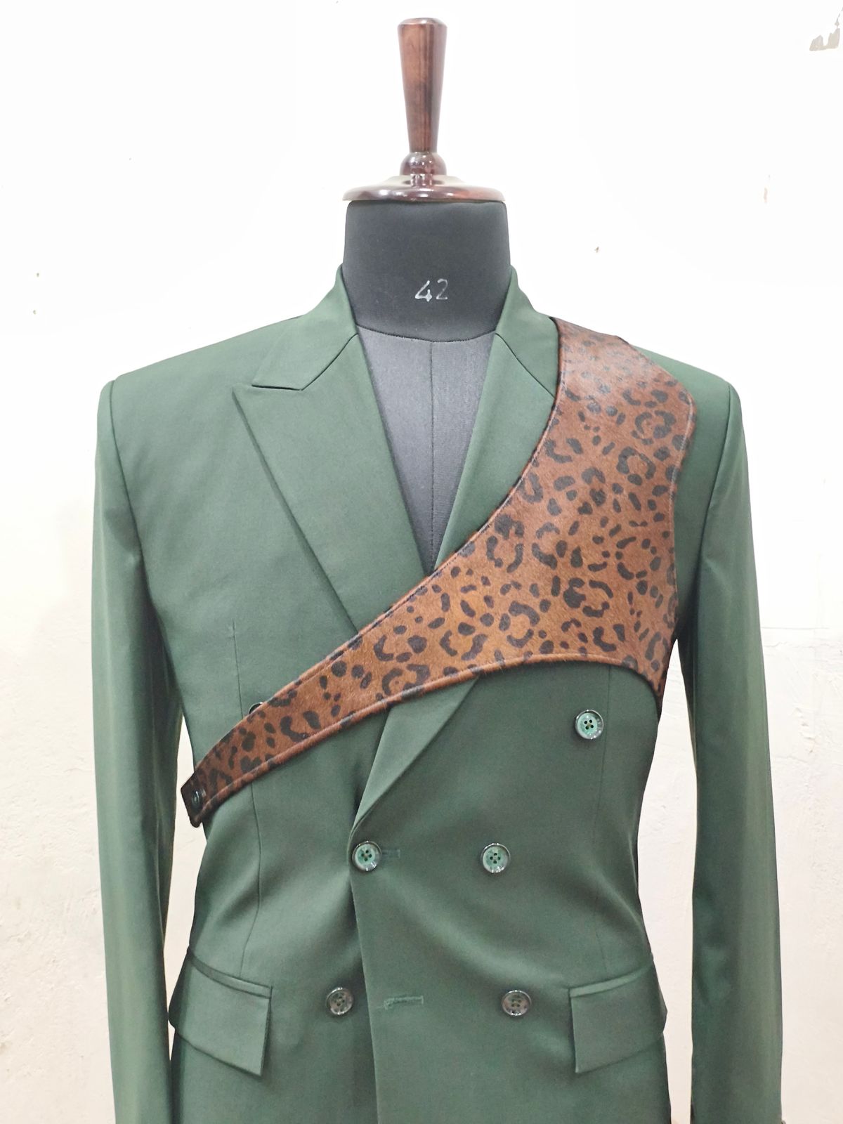 Olive green custom blazer with distinctive leopard print chest panel on mannequin