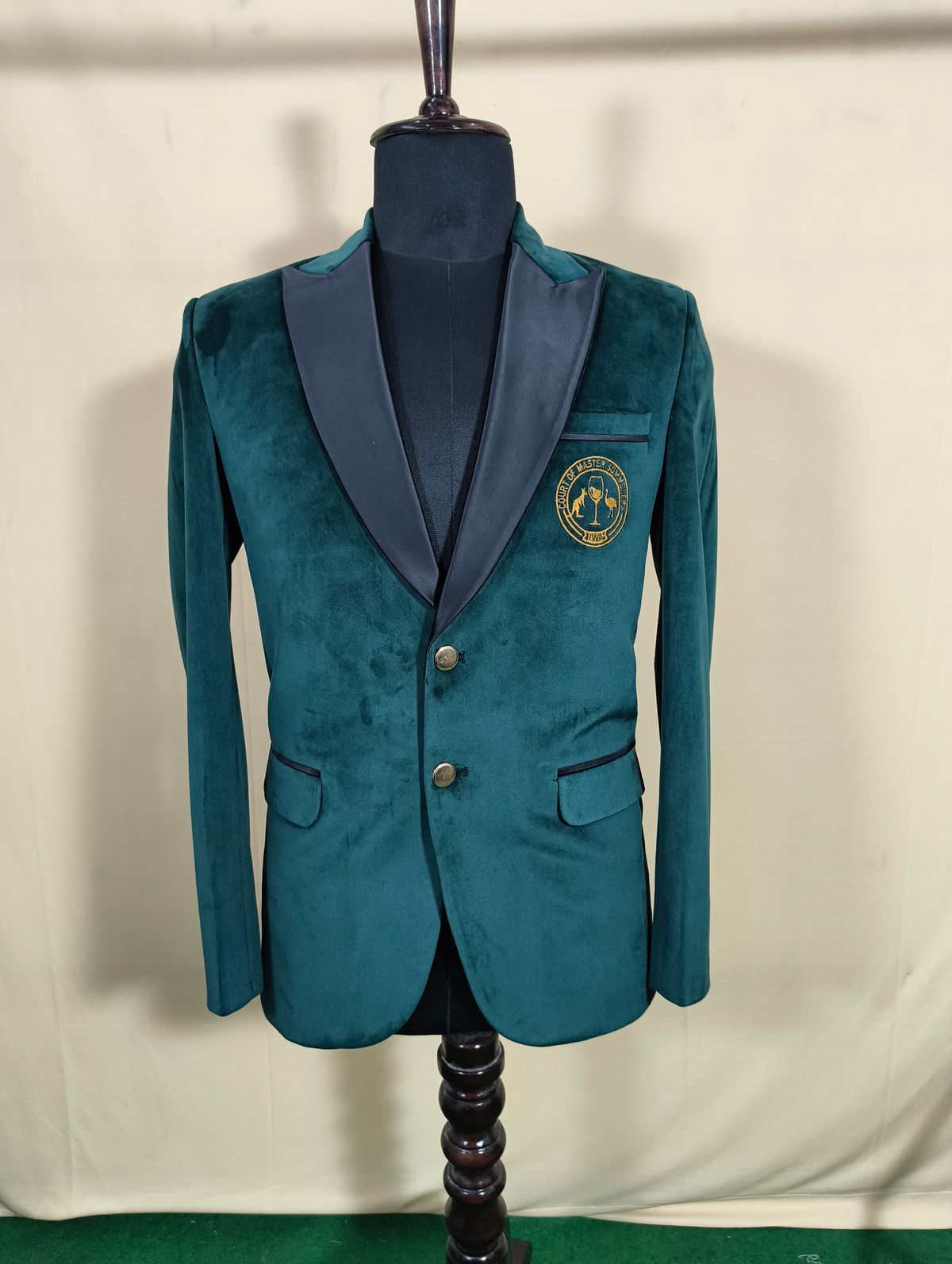 Teal velvet blazer with black satin shawl lapel and embroidered crest detail